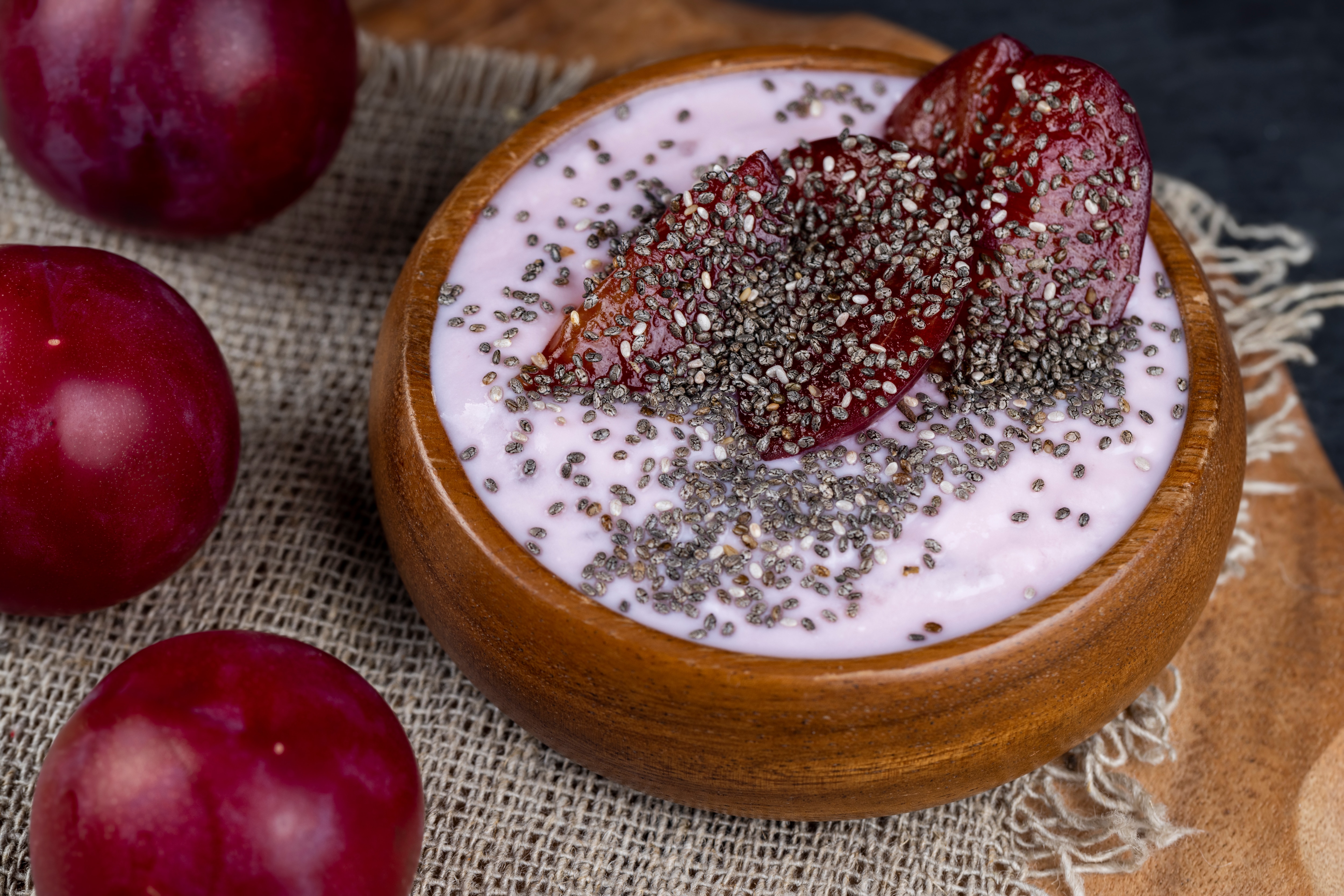A wooden bowl filled with blended dried prunes, chia seeds, banana and almond milk. 